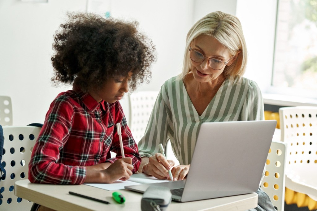 A facilitator and a learner working together at a desk